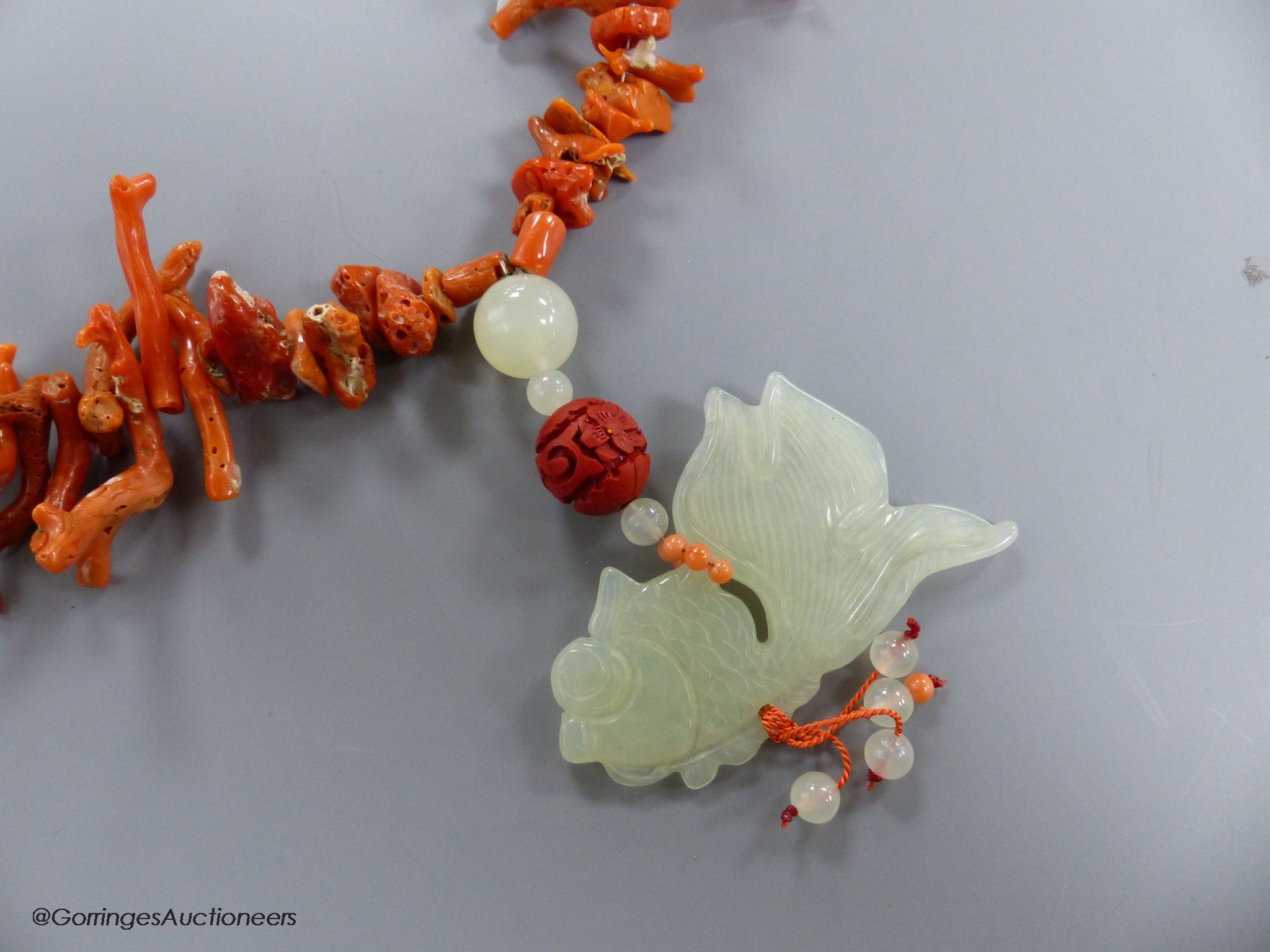 A jagged coral bead necklace, with jade pendant, carved as a fish, necklace approx. 88cm, fish length 66mm, gross weight 114 grams.